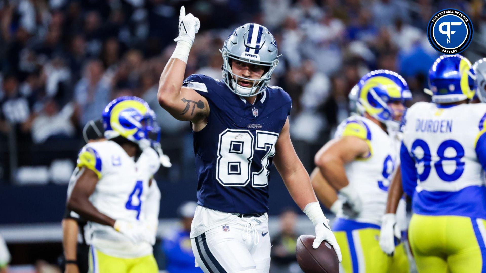 Jake Ferguson (87) celebrates after catching a touchdown pass during the first quarter against the Los Angeles Rams at AT&T Stadium.