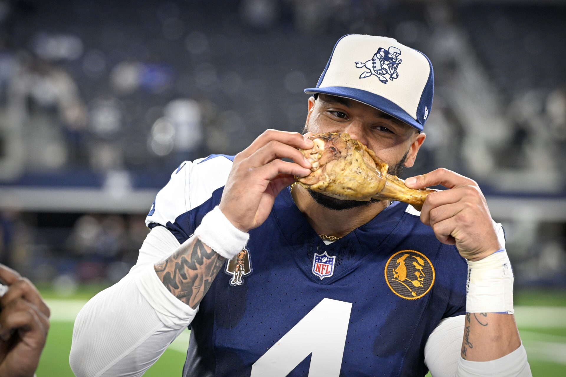Dallas Cowboys Dak Prescott (4) eats a turkey leg after the Cowboys victory over the Washington Commanders at AT&T Stadium.