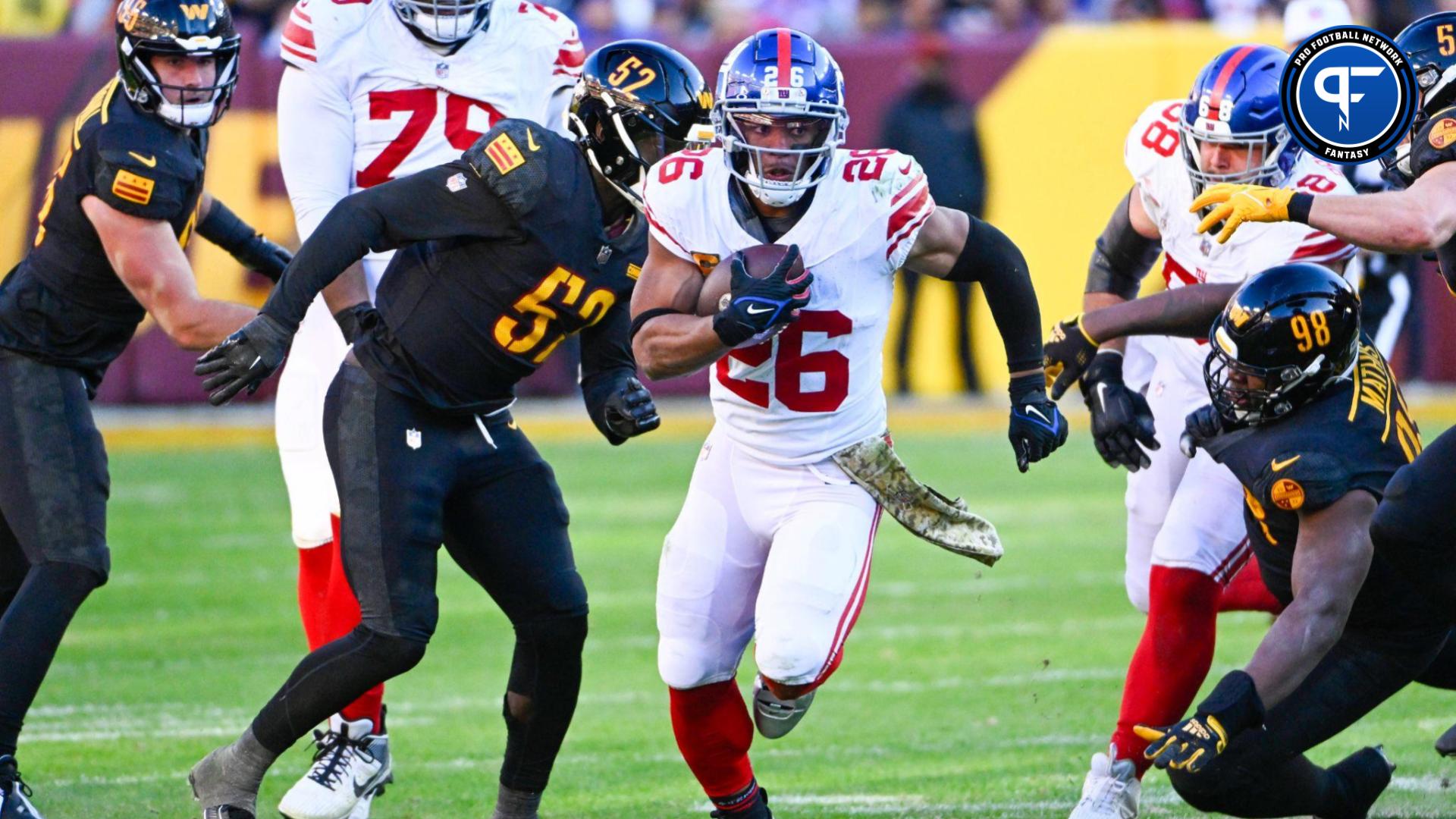 New York Giants running back Saquon Barkley (26) carries the ball against the Washington Commanders during the second half at FedExField.