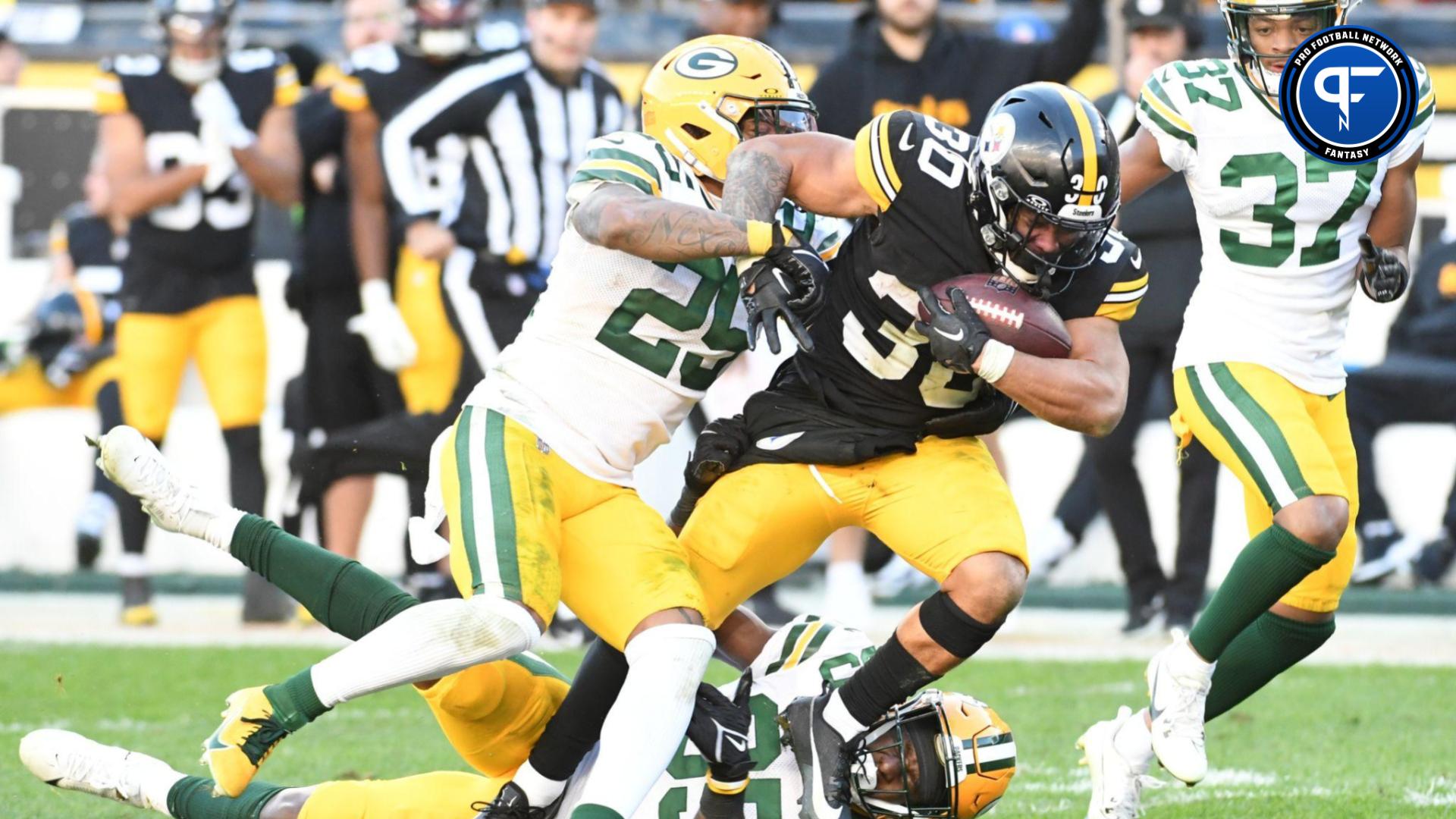 Pittsburgh Steelers running back Jaylen Warren (30) is tackled by Green Bay Packers cornerbacks Keisean Nixon (25) and Corey Ballentine (35) during the fourth quarter at Acrisure Stadium.