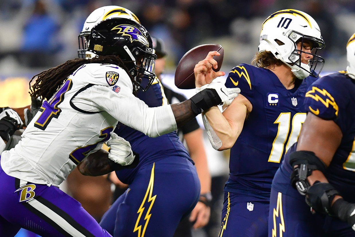 Baltimore Ravens linebacker Jadeveon Clowney (24) strips the ball from Los Angeles Chargers quarterback Justin Herbert (10) during the second half at SoFi Stadium.