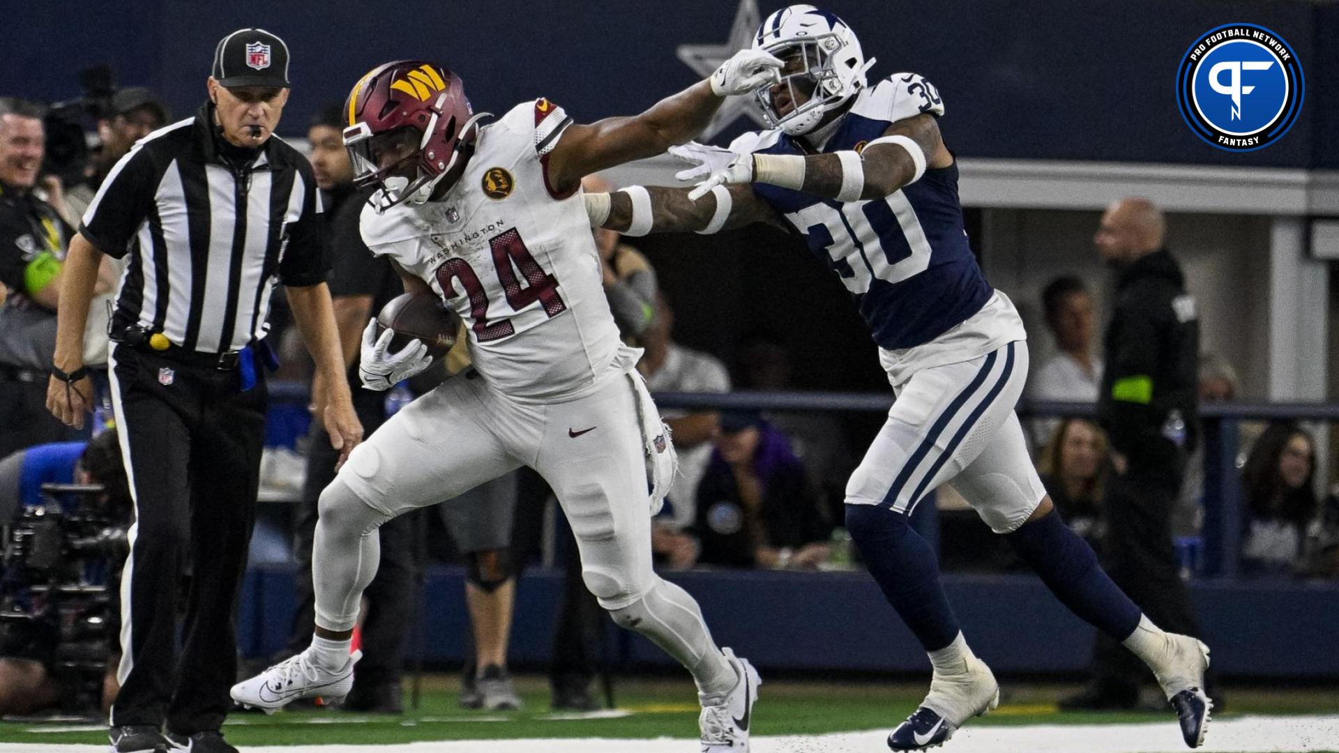 Antonio Gibson (24) and Dallas Cowboys safety Juanyeh Thomas (30) in action during the game between the Dallas Cowboys and the Washington Commanders at AT&T Stadium.