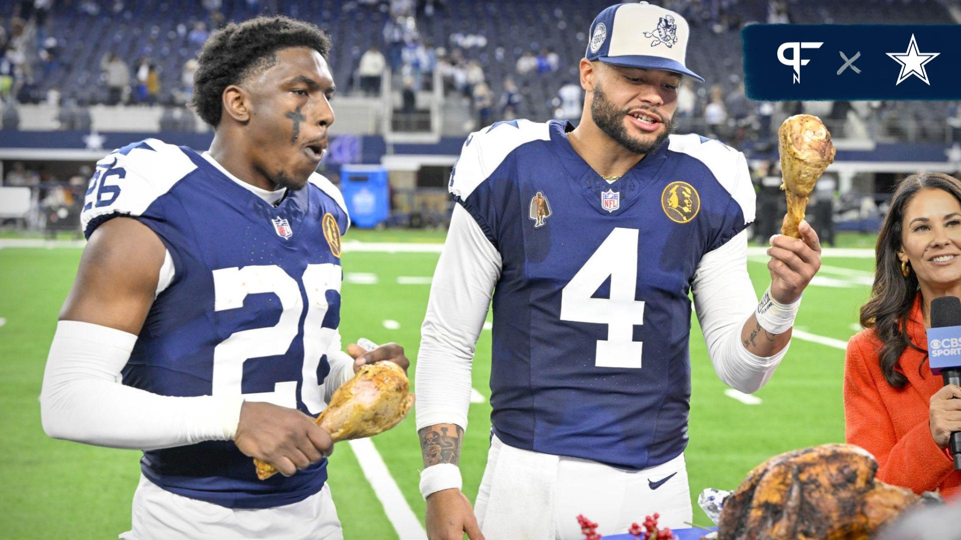 Dallas Cowboys cornerback DaRon Bland (26) and quarterback Dak Prescott (4) eat turkey legs after the Cowboys victory over the Washington Commanders at AT&T Stadium.