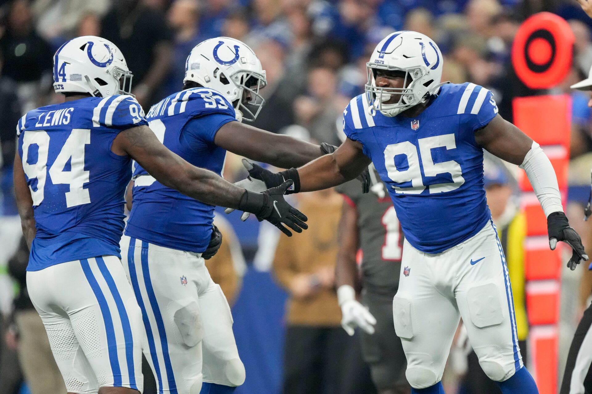 Indianapolis Colts defensive end Tyquan Lewis (94), Indianapolis Colts defensive tackle Eric Johnson II (93) and Indianapolis Colts defensive end Adetomiwa Adebawore (95) celebrate a sack Sunday, Nov. 26, 2023, during a game against the Tampa Bay Buccaneers at Lucas Oil Stadium in Indianapolis.