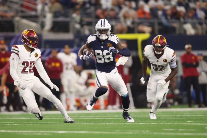 Dallas Cowboys wide receiver CeeDee Lamb (88) runs the ball after catching a pass against Washington Commanders cornerback Benjamin St-Juste (25) and linebacker Jamin Davis (52) in the second quarter at AT&T Stadium.