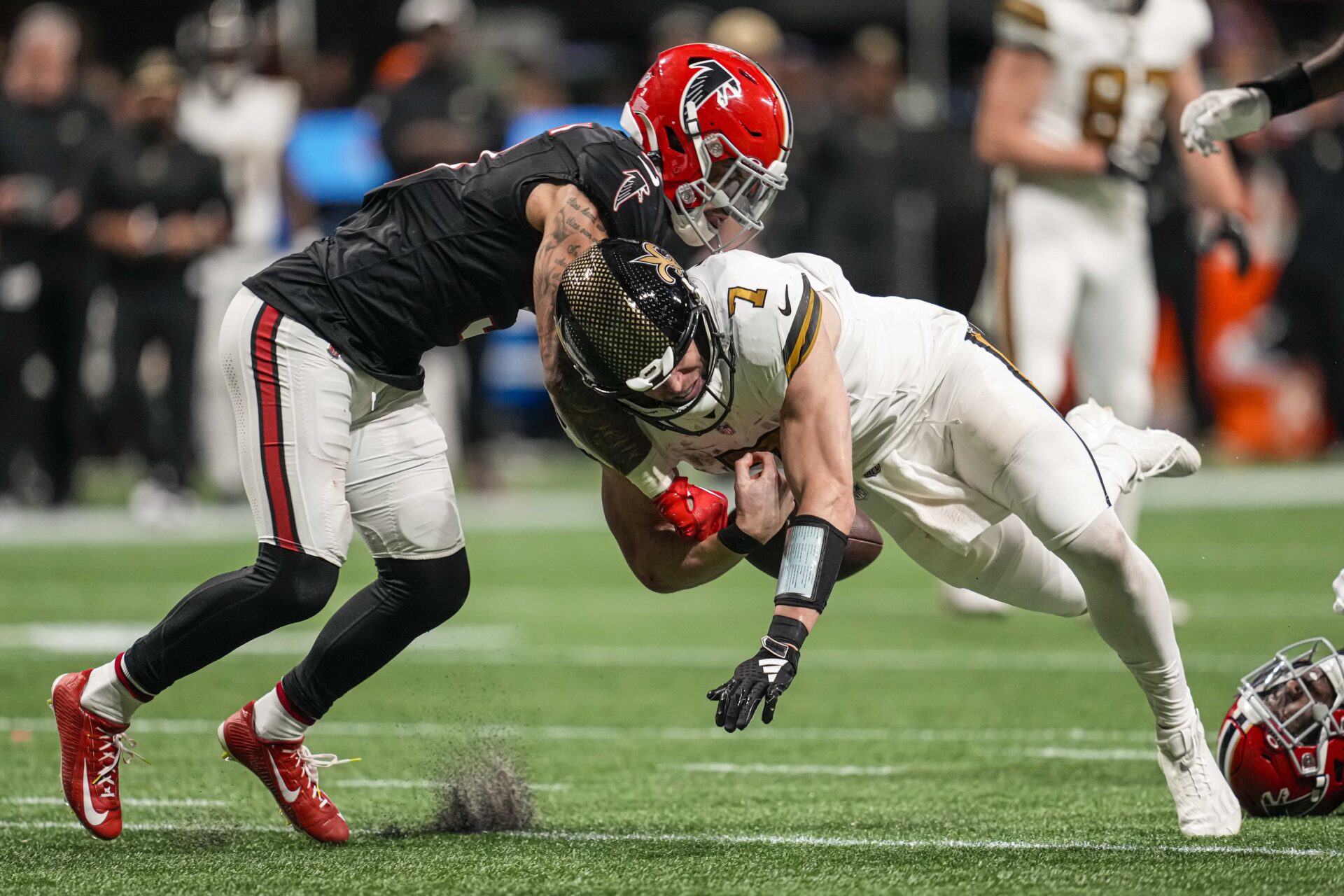 New Orleans Saints quarterback Taysom Hill (7) fumbles when hit by Atlanta Falcons safety Jessie Bates III (3) during the second half at Mercedes-Benz Stadium
