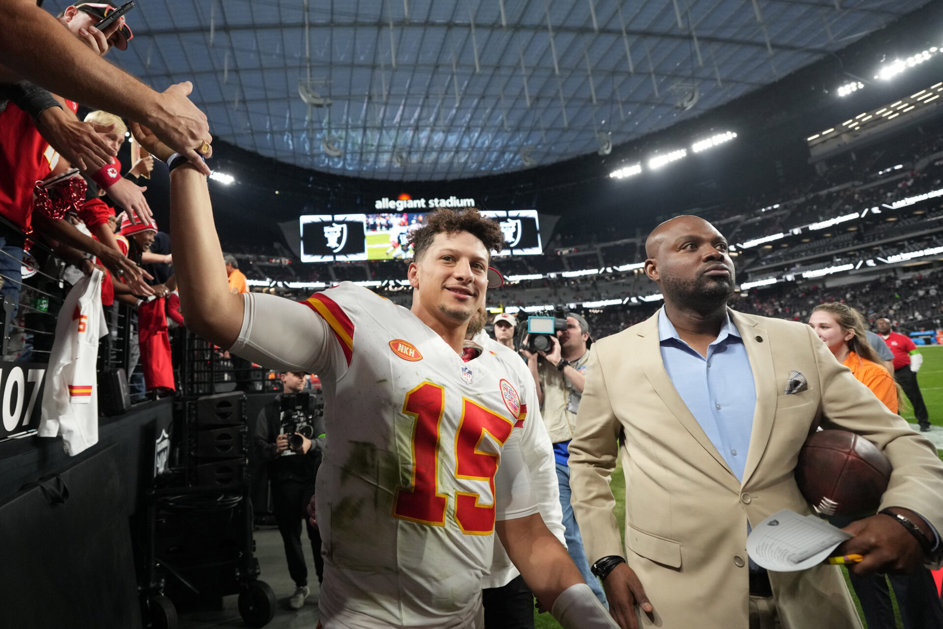 Kansas City Chiefs quarterback Patrick Mahomes (15) is escorted by executive vice president of communications Ted Crews after the game against the Las Vegas Raiders Allegiant Stadium.