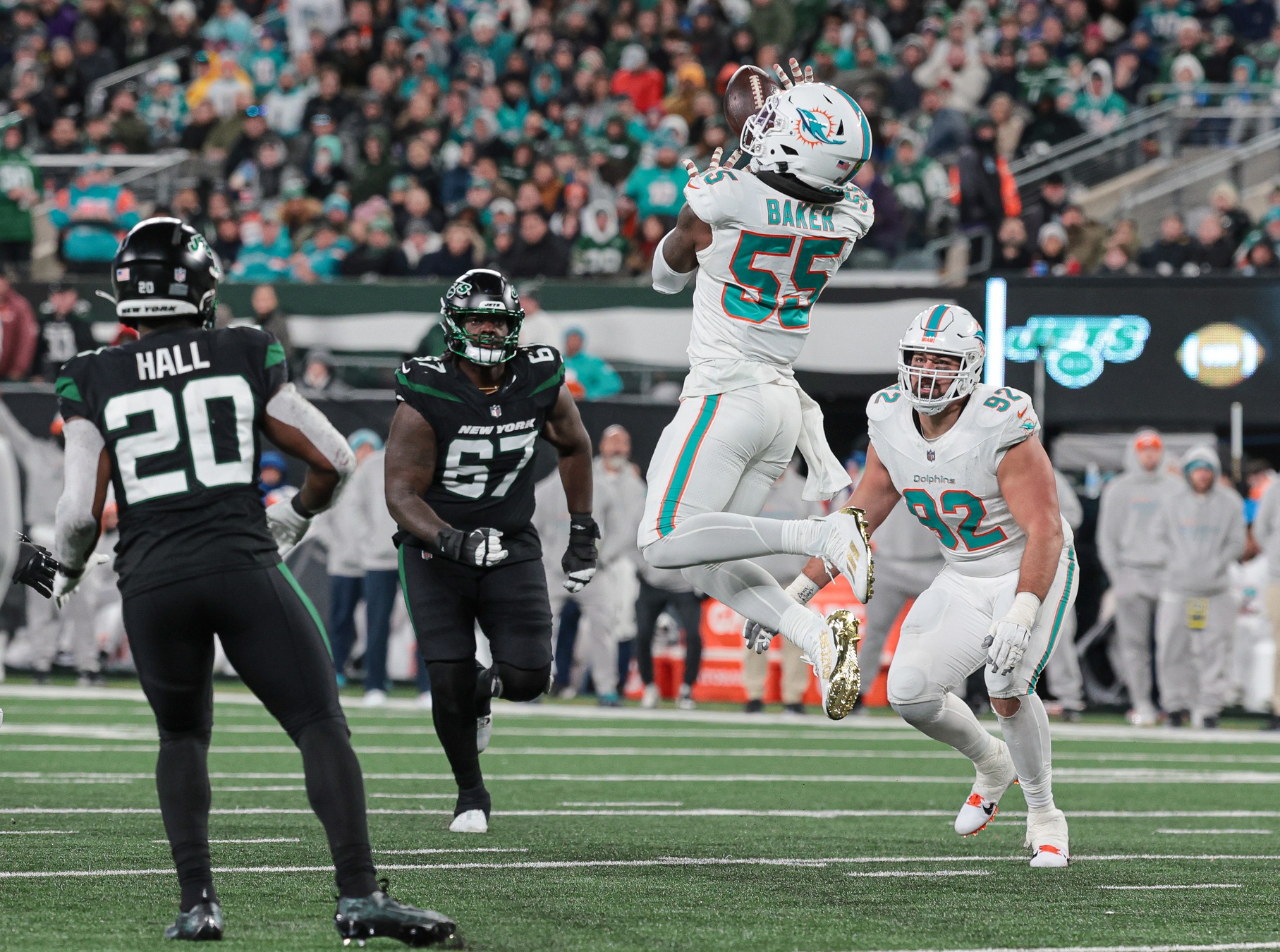 Miami Dolphins linebacker Jerome Baker (55) intercepts a pass in front of New York Jets running back Breece Hall (20).