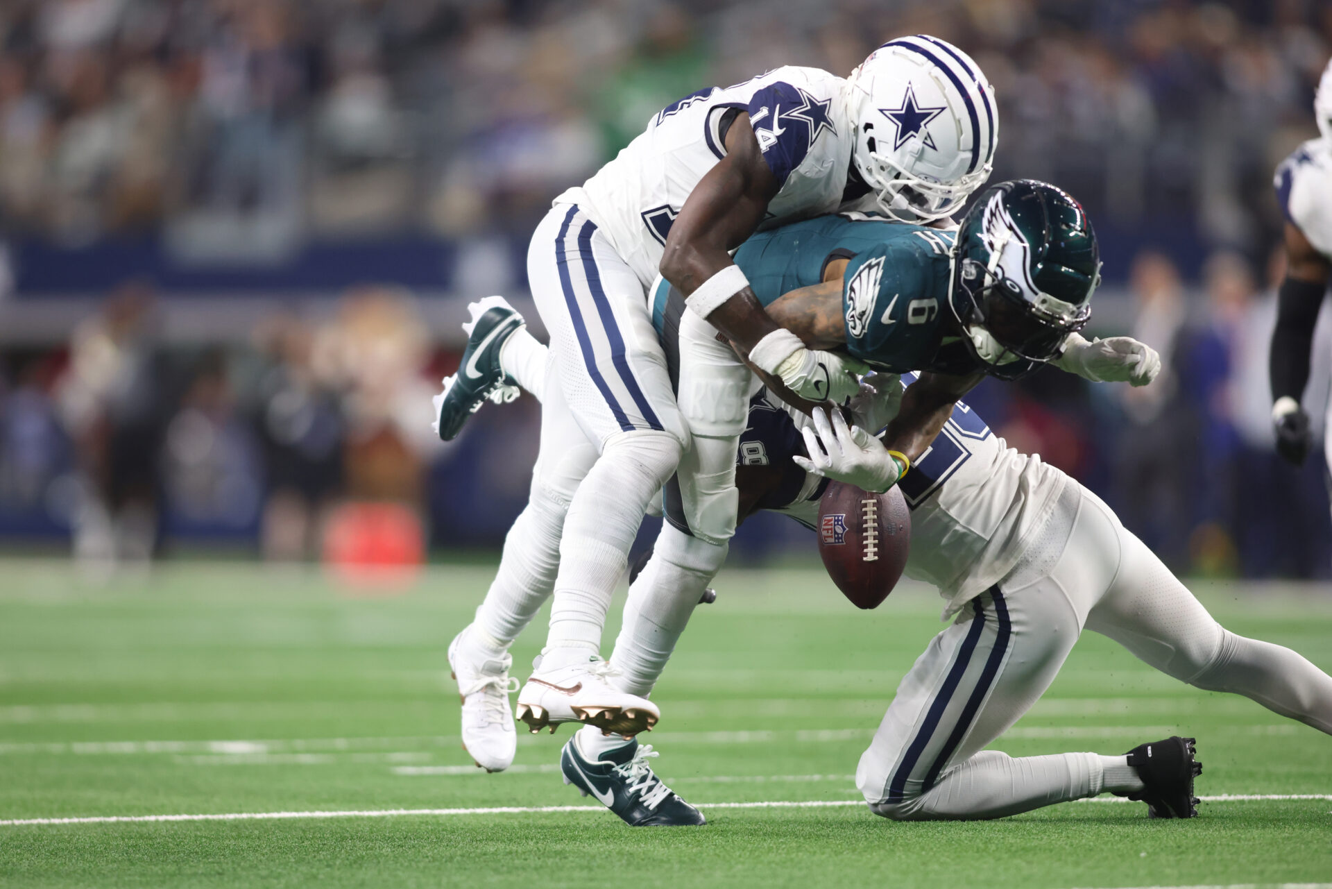 Philadelphia Eagles wide receiver DeVonta Smith (6) fumbles the ball after being hit by Dallas Cowboys safety Markquese Bell (14) in the fourth quarter at AT&T Stadium.