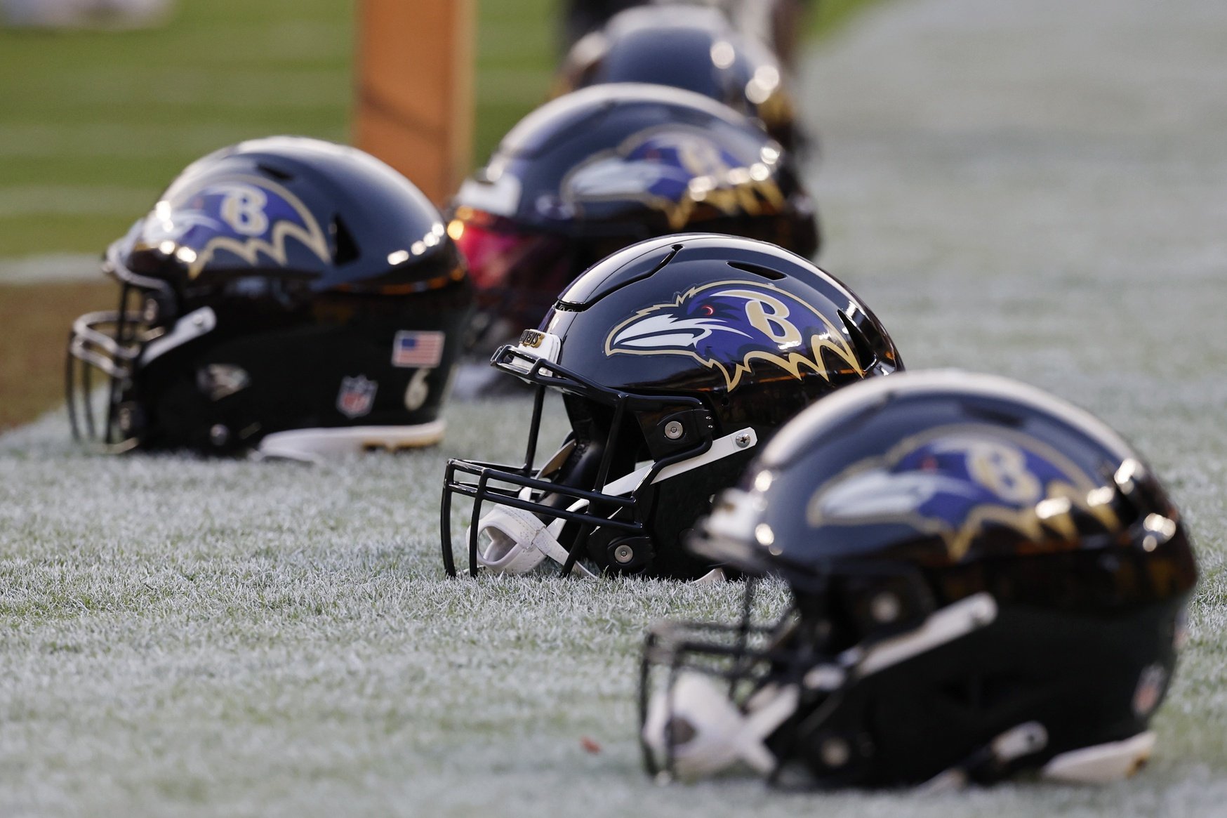Several Baltimore Ravens helmets on the sidelines during a game.