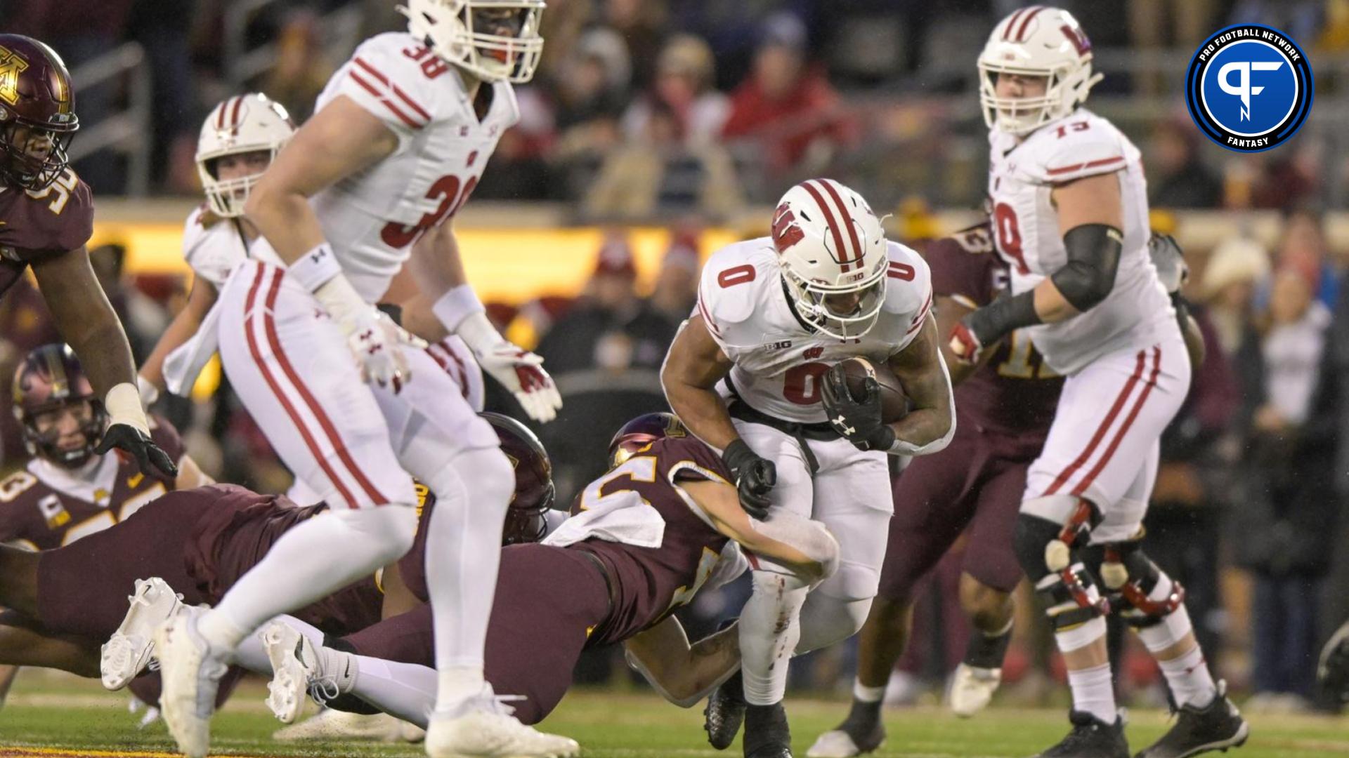 Nov 25, 2023; Minneapolis, Minnesota, USA; Wisconsin Badgers running back Braelon Allen (0) breaks a tackle on his way to a 50-yard run against the Minnesota Golden Gophers during the third quarter at Huntington Bank Stadium.