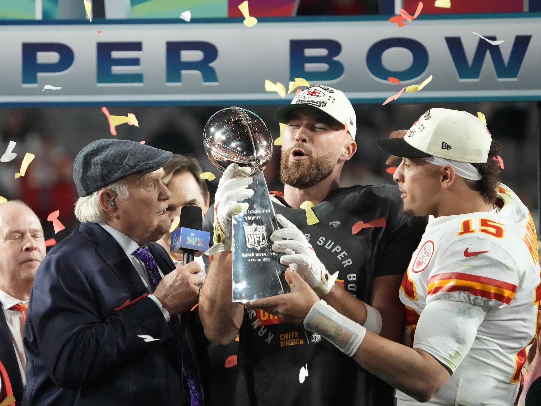 Kansas City Chiefs quarterback Patrick Mahomes (15) passes the the Lombardi Trophy to tight end Travis Kelce (87) after defeating the Philadelphia Eagles in Super Bowl LVII at State Farm Stadium.