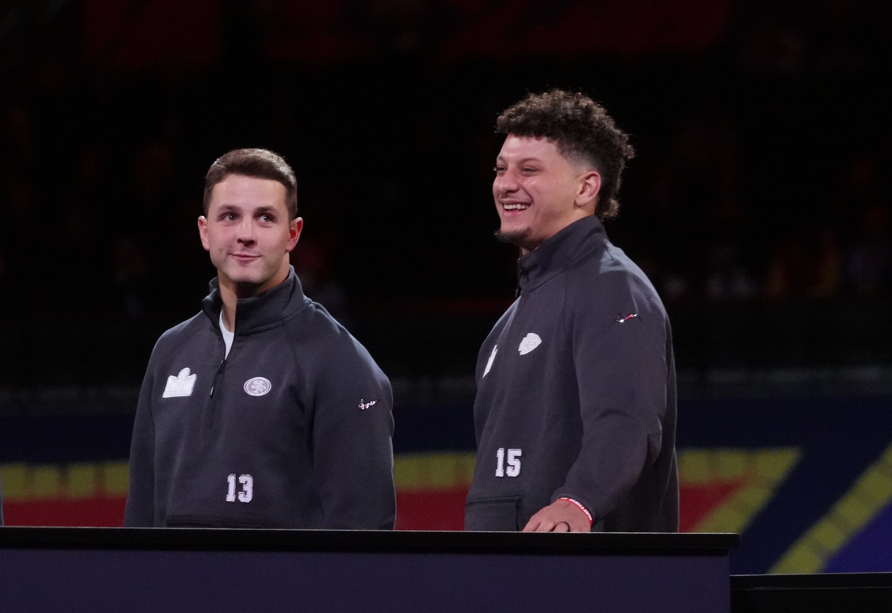 San Francisco 49ers quarterback Brock Purdy (13) and Kansas City Chiefs quarterback Patrick Mahomes (15) stand on stage together during Super Bowl LVIII Opening Night at Allegiant Stadium.