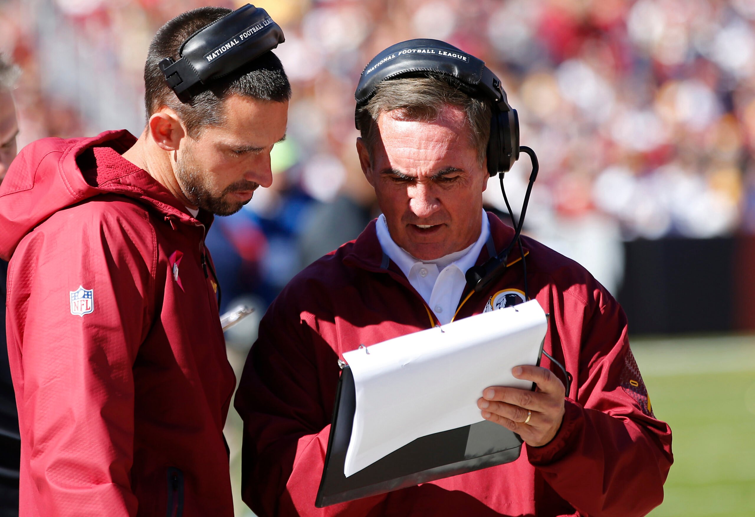 Washington Redskins offensive coordinator Kyle Shanahan ( l ) talks with Redskins head coach Mike Shanahan ( r ) on the sidelines against the Chicago Bears at FedEx Field.