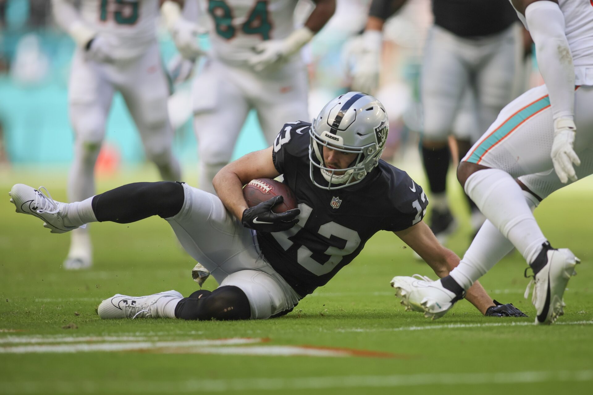 Las Vegas Raiders wide receiver Hunter Renfrow (13) slides after running with the football against the Miami Dolphins during the first quarter at Hard Rock Stadium.