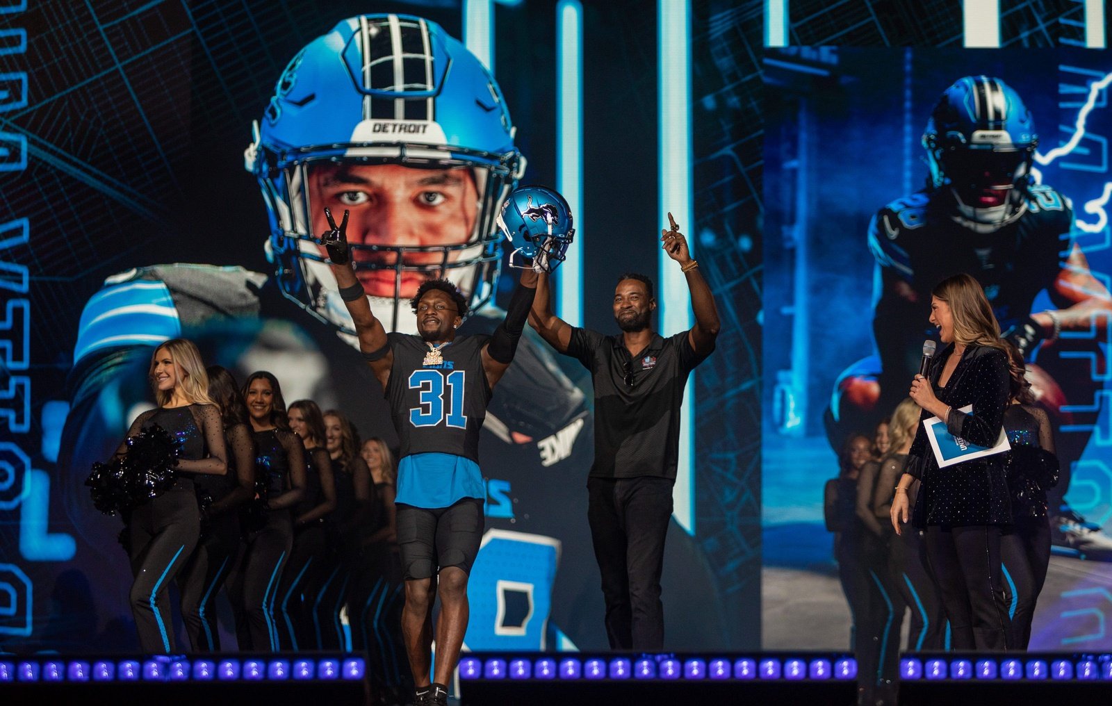 Kerby Joseph (31) and Calvin Johnson stand on stage during the Detroit Lions' new uniform reveal event inside Ford Field in Detroit on Thursday, April 18, 2024.