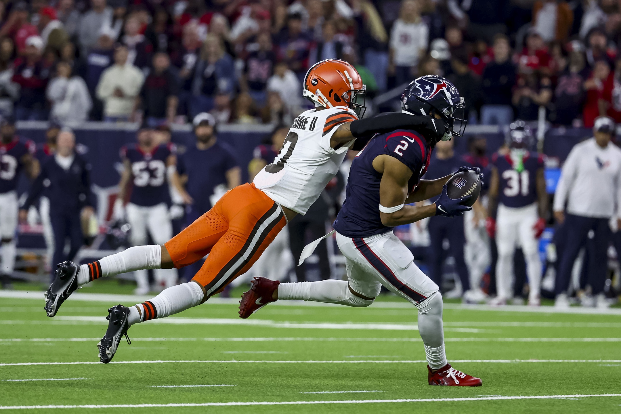 Cleveland Browns cornerback Greg Newsome II (0) tackled Houston Texans wide receiver Robert Woods (2) after an interception during the third quarter in a 2024 AFC wild card game at NRG Stadium. Mandatory Credit: Troy Taormina-USA TODAY Sports