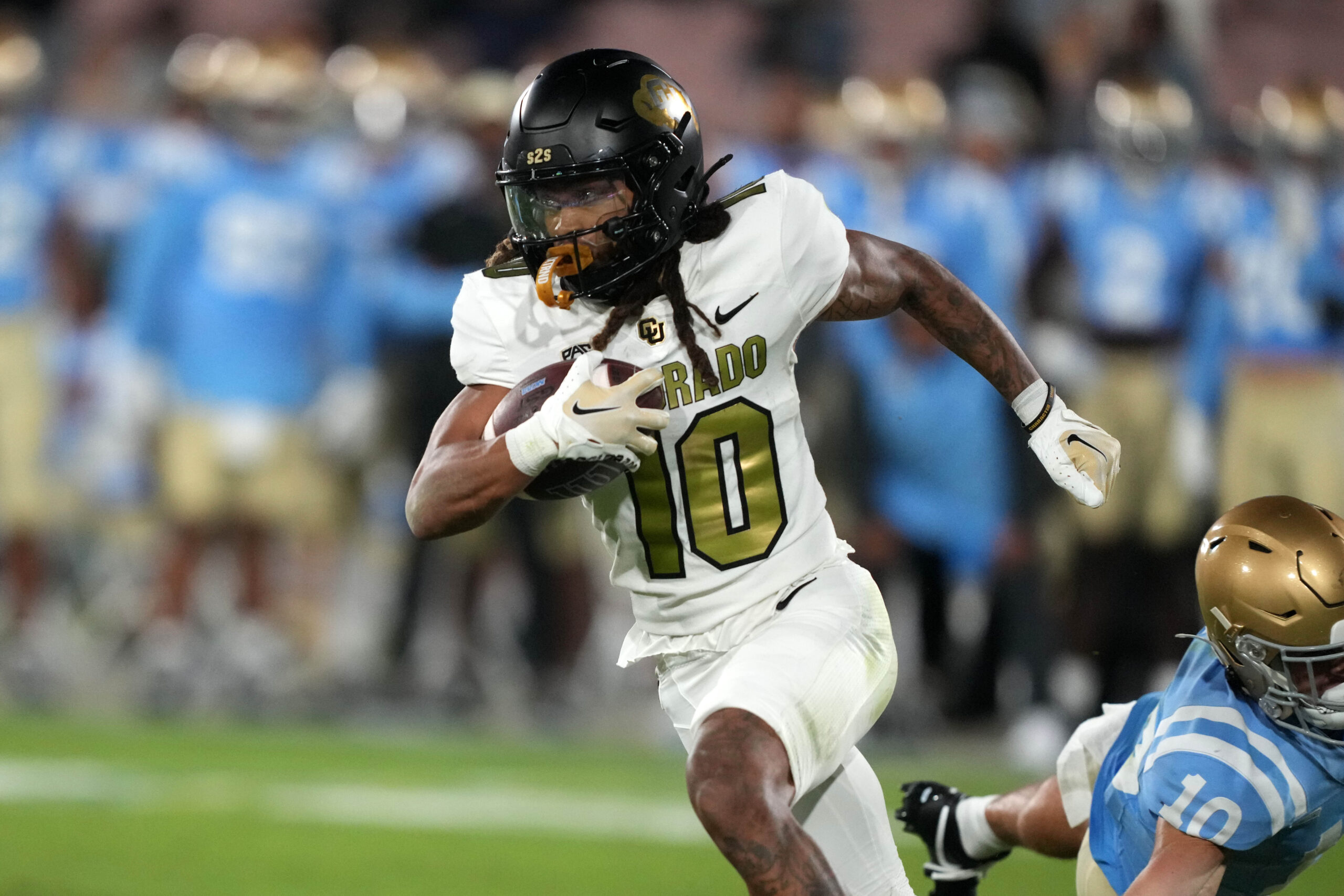 Colorado Buffaloes wide receiver Xavier Weaver (10) carries the ball against the UCLA Bruins in the second half at Rose Bowl.