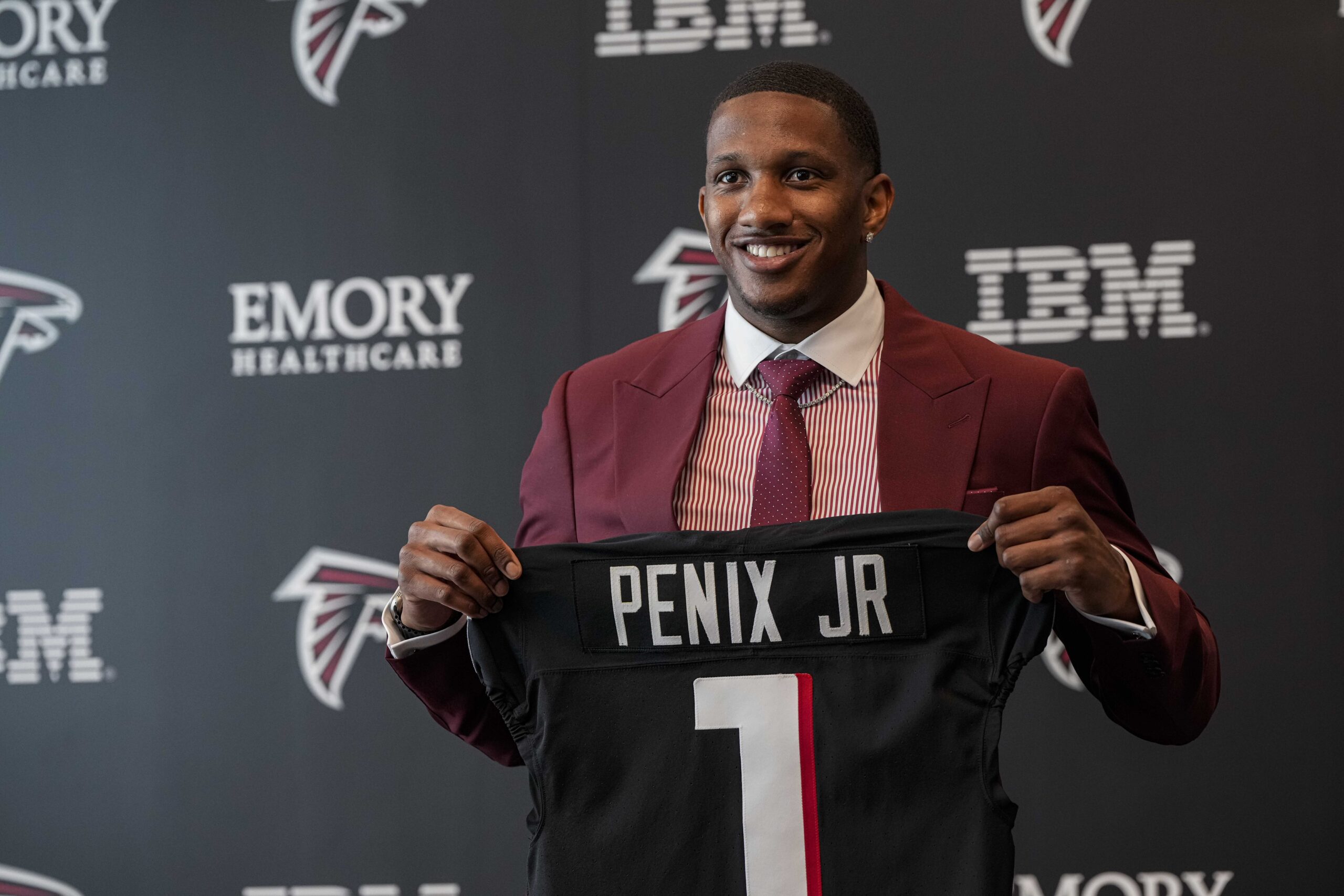 Quarterback Michael Penix Jr. poses for pictures after the Atlanta Falcons selected him in the 2024 NFL Draft.