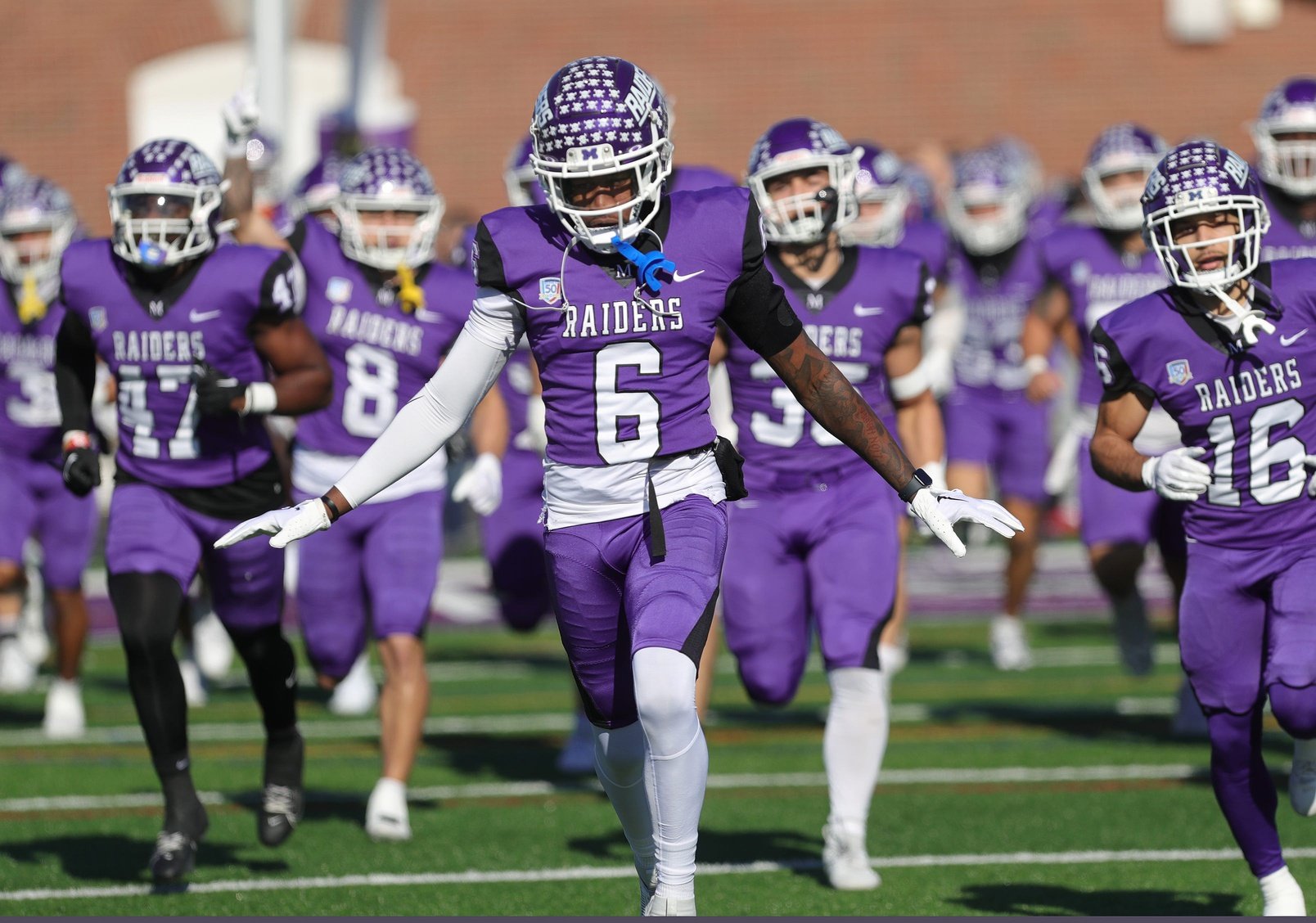 Mount Union wide receiver Wayne Ruby (6) leads the Purple Raiders onto the field before the start of their first-round NCAA Division III playoff game against Alfred State, Saturday, Nov. 18, 2023.