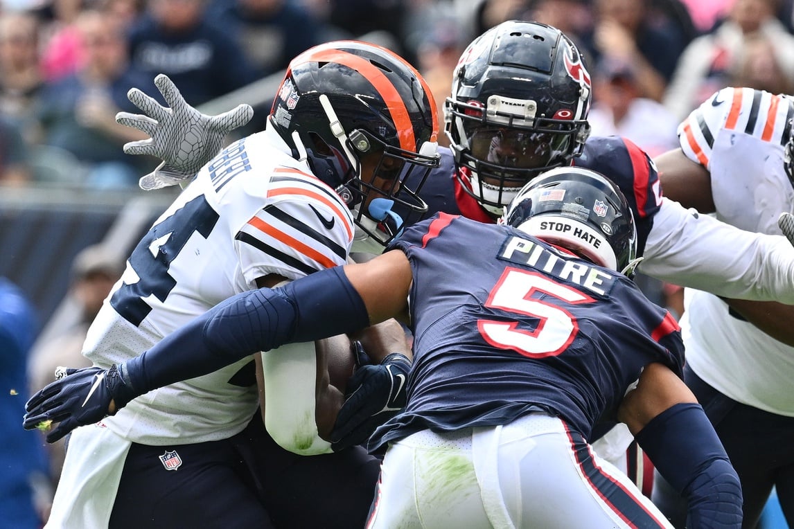 Chicago Bears running back Khalil Herbert (24) is surrounded by Houston Texans defensive back Jalen Pitre (5) and defensive lineman Jerry Hughes (55) for a backfield tackle in the third quarter at Soldier Field. Mandatory Credit: Jamie Sabau-USA TODAY Sports