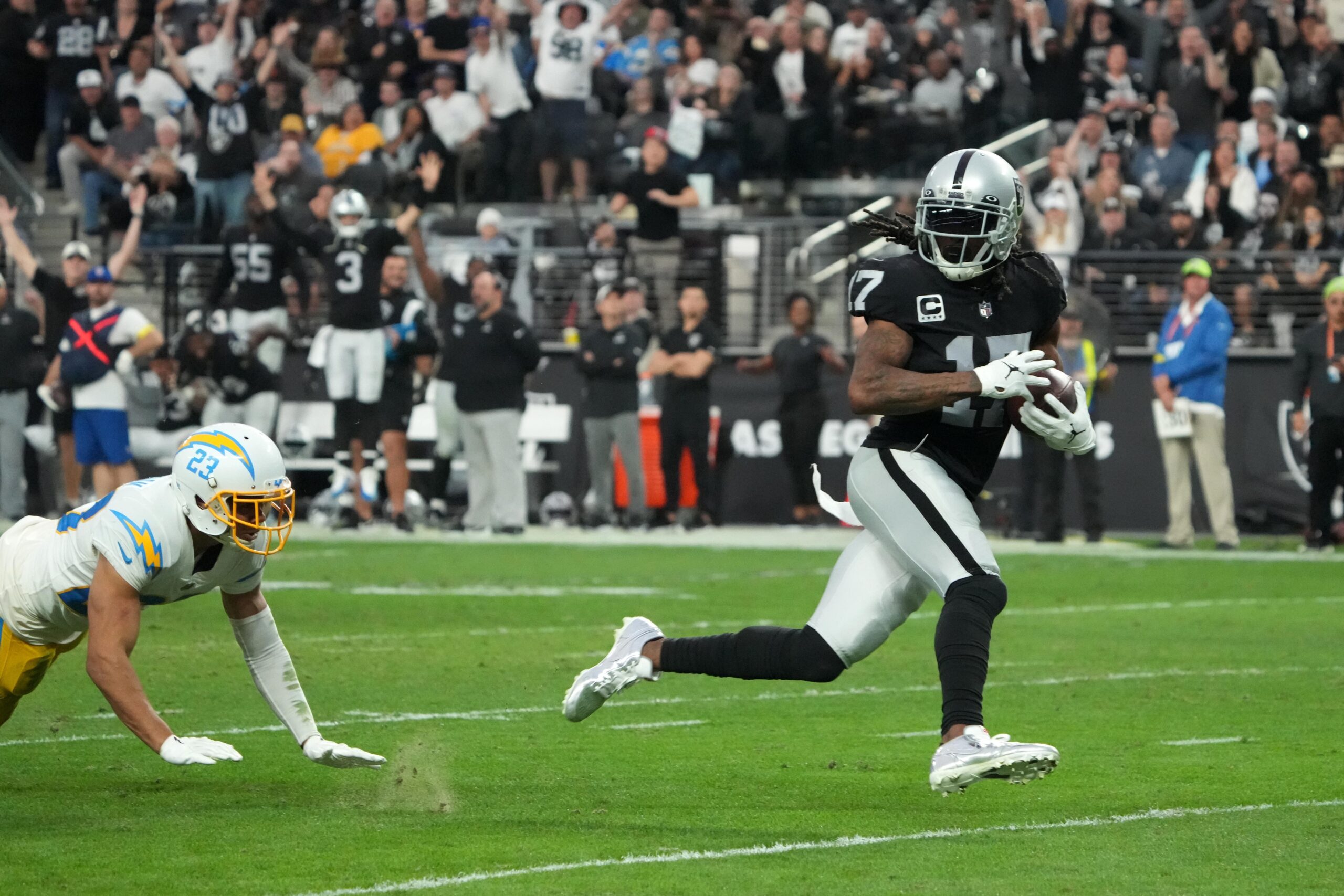 Las Vegas Raiders wide receiver Davante Adams (17) scores on a 45-yard touchdown reception against Los Angeles Chargers cornerback Bryce Callahan (23) n the second half at Allegiant Stadium. The Raiders defeated the Chargers 27-20. Mandatory Credit: Kirby Lee-USA TODAY Sports