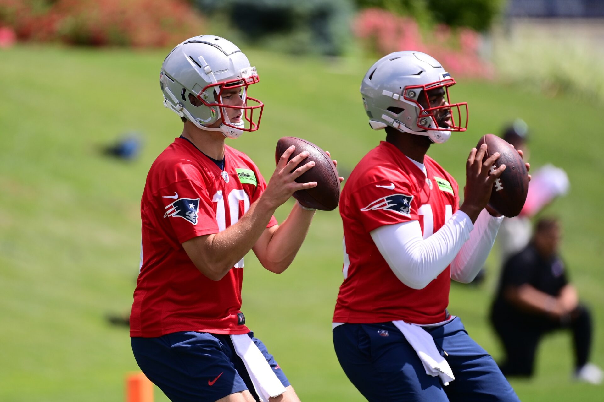 New England Patriots quarterbacks Drake Maye (10) and Jacoby Brissett (14) throw passes during the team's minicamp.